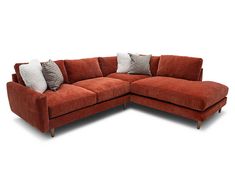 an orange sectional sofa with pillows on the top and bottom corner, in front of a white background