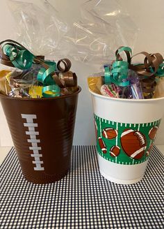 two plastic cups with football themed decorations on them