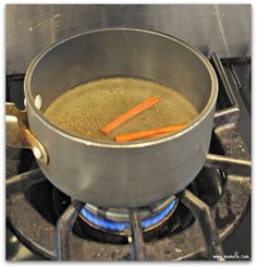 a pan with some food cooking on top of a gas burner in a kitchen