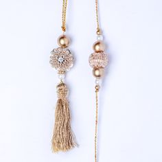 Express your love with this premium gold work bhaiya bhabhi rakhi set. A stunning set, it comprises of artistically designed rakhis with a gold-work pendant at the center. Gold and white beads adorn the 1-inch pendant on two sides, while a gold latkan adds to the beauty of the rakhi for bhabhi. Order this designer set today. Gold Meenakari Tikka For Gift, Gold Tikka For Navratri Gift, Gold Tikka With Intricate Design For Gift, Gold Tikka With Intricate Design As Gift, White Tikka As Gift In Temple Jewelry Style, Zari Work Jewelry For Eid Puja, Eid Jewelry With Zari Work For Puja, Zari Work Jewelry For Puja And Eid, Gold Hand Set Tikka For Gift