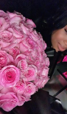 a woman holding a bouquet of pink roses