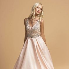 This Enchanting Gown Is Designed To Make You Feel Like A True Princess, Radiating Elegance And Sophistication At Any Special Occasion. The Skirt Of The Gown Is Layered, Adding Depth And Dimension To Your Overall Look. It Creates A Stunning Visual Effect, Making You Look Like You're Walking On Air. And The Best Part? It Even Comes With Pockets, Allowing You To Keep Your Essentials Close By And Adding A Modern And Practical Touch To The Dress. Length: Long Color: Blush Neckline: Illusion Deep V-Ne Sleeveless Ball Gown With Lace Bodice For Prom, Sleeveless Lace Bodice Ball Gown For Prom Season, Sleeveless Lace Bodice Ball Gown For Prom, V-neck Evening Dress With Sheer Bodice For Gala, Sleeveless Ball Gown With Illusion Neckline For Prom, Elegant Sleeveless Ball Gown With Lace Bodice, Sleeveless Dresses With Illusion Neckline For Debutante Ball, Fitted Bodice V-neck Dress For Debutante Ball, Elegant Sleeveless Gown For Debutante Ball