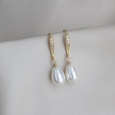 White Pear Pearl Gold Earrings Perfect for bridal parties! Beautiful gold-filled wire wrapped white pear crystal pearl drop earrings complimented with gold plated ear wires with cubic zirconia accents down the center. TAKE 10% OFF $75 OR MORE WITH COUPON CODE ~ WEDDINGS10 TAKE 15% OFF $100 OR MORE WITH COUPON CODE ~ WEDDINGS15 Each pair of earrings will arrive in a box tied with a ribbon perfect for gift giving. Also, included will be a polish pad, anti-tarnish bag with an anti-tarnish tab for s White Pear-shaped Party Jewelry, Pear-shaped White Bridal Earrings For Anniversary, White Elegant Dangle Teardrop Earrings, White Elegant Teardrop Dangle Earrings, White Dangle Teardrop Earrings With Elegant Design, Delicate White Pear-shaped Bridal Earrings, White Teardrop Earrings With Elegant Design For Gifts, White Pear-shaped Pearl Earrings For Wedding, Pear-shaped White Pearl Earrings For Wedding