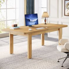 a desk with a computer on it in front of a window and chair next to it