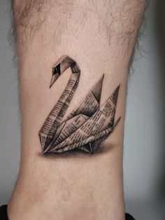 a black and white photo of a neck tattoo with a paper boat on it's side