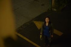 a woman standing in the middle of an empty parking lot