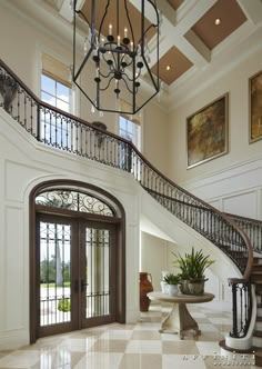 a foyer with marble flooring and wrought iron railings leading up to the second story