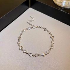 Elevate your style with our Trendy Women's Heart-Shaped Silver Bracelet. Crafted from high-quality silver, this elegant bracelet features a charming heart design that adds a touch of romance to any outfit. Perfect for everyday wear or special occasions, it effortlessly combines sophistication and modern fashion. A great gift for yourself or a loved one, this bracelet is a must-have accessory for any jewelry collection. Elegant Alloy Heart Bracelet, Elegant Adjustable Alloy Heart Bracelet, Elegant Silver Heart Bracelet For Valentine's Day, Silver Heart-shaped Alloy Bracelets, Elegant Silver Heart Chain Bracelet, Dainty Silver Bracelets For Valentine's Day, Silver Dainty Bracelet For Valentine's Day, Dainty Silver Bracelet For Valentine's Day, Valentine's Day Heart-shaped Alloy Bracelet