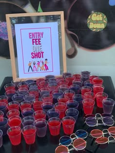 many glasses are lined up in front of a sign that says entry fee one shot