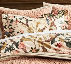 the comforter is made up with pink flowers and birds