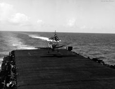 a small plane is on the deck of a ship in the middle of the ocean