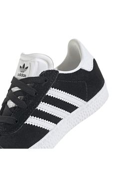 Initially designed in '91 as a training shoe for top athletes, the iconic Gazelle sneaker has been refreshed with stretchy laces for your little athlete. Pull-on style with elastic laces Leather and synthetic upper/textile lining/rubber sole Imported Sporty Black Sneakers With White Laces, Black Sporty Sneakers With White Laces, Black Lace-up Sneakers With White Laces, White Adidas Sneakers With Elastic Laces, Non-slip High-top Sneakers For Training, Casual Lace-up Skate Shoes For Training, Adidas Non-slip Sneakers For Sports, Adidas Sports Sneakers, Adidas Training Sneakers With Laces