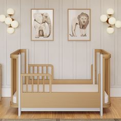 a baby crib in a room with two pictures on the wall