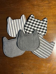 four baby bibs laying on top of a wooden table