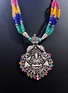 Very attractive hand crafted Goddess Laxmi pendant and earrings in oxidized silver with colorful crystal bead necklace. The pendant is cast metal, using the wax technique, so it has deep details and 3D relief. It has the lustrous patina of a vintage tribal piece. Hindu goddess Laxmi is flanked by her elephants, and crowned by peacocks in 3D. This is a handcrafted piece, therein lies the charm and interest of this piece. Beautiful sparkly necklace with faceted beads transitions to a fine twisted India Necklace, Goddess Laxmi, Oxidised Silver Jewelry, Sparkly Necklace, Hindu Goddess, Thread Necklace, Goddess Jewelry, Elephant Bracelet, Indian Necklace