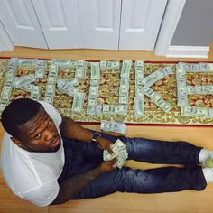 a man sitting on the floor with money in his hands