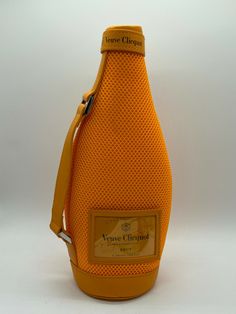 an orange wine bottle with a yellow strap