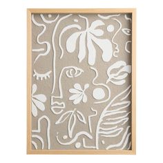 a white and beige abstract painting in a wooden frame on a gray wall with leaves