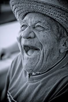 an old man wearing a hat and making a funny face with his mouth wide open