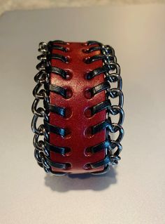 Genuine russet leather cuff bracelet in rick dark brown or deep red.  Each bracelet has black leather stitches on each side with metal link chain weaved through the stitches.  There are 3 matching metal snaps so you can adjust it to your wrist measurement and the cuffs fit both women or mens wrists. To see more leather items, jewelry and gifts, please click this link; https://lacostaskreations.etsy.com Leather Bracelet With Black Band, Punk Style Leather Wristband As Gift, Punk Style Leather Jewelry With Wrist Strap, Leather Bracelet With Black Band As Fashion Accessory, Handmade Punk Leather Bracelet As Gift, Punk Style Leather Strap Bracelets, Punk Style Brown Leather Jewelry, Black Band Leather Bracelet, Punk Leather Jewelry With Wrist Strap