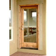 a wooden door is open on the outside of a house with wood flooring and windows