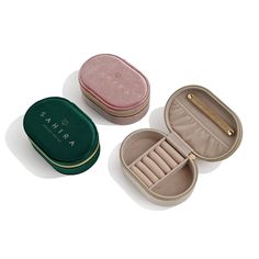 three small jewelry cases sitting next to each other on a white surface with the lid open