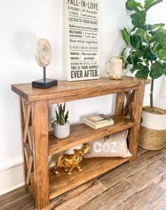 a wooden shelf sitting on top of a hard wood floor next to a potted plant