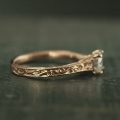 a close up view of a gold ring with a diamond on it's side