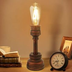 an old fashioned lamp with a light bulb on top of it next to some books