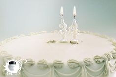 two candles on top of a white cake