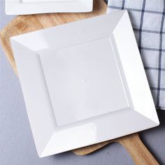 a white plate sitting on top of a wooden cutting board