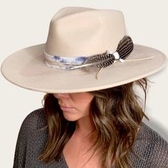 The Amelia is made from 100% Australian wool felt and has a classic wide cut brim, featuring a jute rope tie and feather trim. Details 100% Australian wool felt Brim: 3.75"Crown: 4.5"Size: O/S with a size adjuster for customizable sizing capability. The velcro ribbon size adjuster is tucked into the sweatband on the inside of the hat. How to clean: Spot clean using a damp cloth and mild soap. Air dry in an area free from direct sunlight. Adjustable Beige Fur Felt Fedora, Adjustable Straw Hat With Flat Brim For Fall, Spring Fedora Hat Band In Fur Felt, Adjustable Fedora Straw Hat For Fall, Spring Adjustable Fur Felt Fedora, Adjustable Fur Felt Fedora For Spring, Felt Fedora With Feather Trim For Rodeo, Rodeo Fedora Felt Hat With Feather Trim, Adjustable Wide Brim Hat With Feather Trim