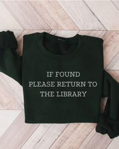 a green sweatshirt with the words if found please return to the library printed on it