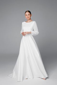 a woman wearing a white wedding dress with long sleeves