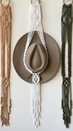 three hats hanging on the wall with macrame beads attached to each hat holder