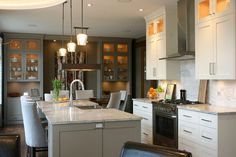 a large kitchen with white cabinets and marble counter tops, along with stainless steel appliances