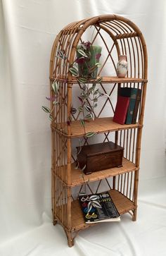 a bamboo shelf with books and flowers in it on a white background next to a book case