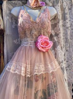 a mannequin wearing a pink dress with flowers on it's waist and neck