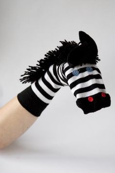 a hand with a black and white striped sock horse