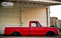 a red truck parked in front of a garage