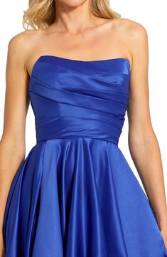 a woman wearing a blue strapless dress