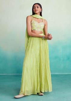 Introducing our zing sharara set in vibrant lime. This 3-piece ensemble includes a hand-embroidered crop top with heart motifs, a micropleated sharara, and a shisha embroidery dupatta. Made from lightweight chanderi fabric, it combines modern charm and comfort, perfect for any occasion. Bollywood Style Sharara With Cutdana For Spring, Green Gota Work Dupatta For Spring, Spring Festive Sharara With Gota Work, Spring Anarkali Sets With Mirror Work, Green Designer Pant Set For Diwali, Anarkali Sets With Mirror Work For Spring, Designer Floor-length Palazzo Set For Spring, Spring Designer Wear Floor-length Palazzo Set, Festive Green Pant Set With Chikankari Embroidery