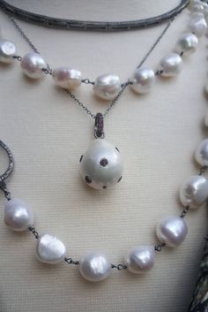 "With an edgy vibe, this pearl necklace is a balance of traditional materials and modern design. Hanging from the oxidized silver chain is a luminous white freshwater baroque pearl studded with emerald, blue sapphire or pink tourmaline stones. Gemstones continue to the bail. Elegant, understated and exuding a casual sophistication, it it a striking departure from the ubiquitous pearl pendant necklace. Necklace length: 16\" plus an extender. Pearl pendant with the bail: 30 - 35mm Please specify w Luxury Drop Pearl Pendant Necklaces, Luxury Pearl Drop Teardrop Pendant Necklace, Luxury White Teardrop Pendant Necklace, Luxury Pearl Drop Teardrop Pendant Jewelry, Luxury Handmade Teardrop Necklaces, Luxury Handmade Teardrop Necklace, Luxury Drop Pearl Pendant Jewelry, Unique Teardrop Pearl Pendant Jewelry, Luxury Drop Shape Pearl Pendant Jewelry