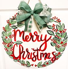 a merry christmas wreath hanging on the front door