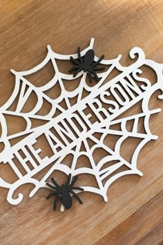 a wooden sign that says the halloweens on it with spider webs and black widowes