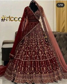 a red bridal gown on display in front of a couch