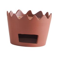 a pink cupcake holder with a brown crown on top and gold glitters in the middle