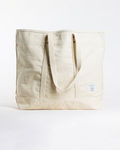 This Large East West Tote from Immodest Cotton is the perfect bag for weekend getaways and trips to the farmers market. With double stitched seams and removable leather handles, this cotton canvas shoulder bag converts to a handheld tote with ease. Not to mention - we love this neutral shade of canvas. Details + Design: Converts from handheld to shoulder with detachable leather handles. Remove the leather handles to wash. One interior pocket. Material: Cotton canvas. Undyed leather handles. Hand Cotton Tote Weekender Bag With Pockets, Rectangular Cotton Weekender Bag With Pockets, Canvas Bag With Reinforced Double Handles, Everyday Duck Canvas Bag With Pockets, Everyday Weekender Bag With Double Reinforced Handles, Everyday Canvas Bag With Duck Canvas Lining, Beige Canvas Bag With Reinforced Handles For Travel, Duck Canvas Tote Bag With Canvas Lining, Everyday Tote Weekender Bag With Canvas Lining