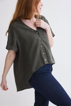 This top is a spring/summer staple exuding effortless charm and versatility with its breathable fabric and casual button-up design. High low silhouette V-neck with button down closure Short sleeves Oversized fit Spring V-neck Top With Placket, Green V-neck Shirt With Button Closure, Cotton V-neck Top With Buttons, Relaxed Fit V-neck Blouse With Buttons, Casual Linen V-neck Shirt, Summer V-neck Tops With Button Cuffs, Summer V-neck Blouse With Button Cuffs, V-neck Tops With Button Closure For Day Out, Oversized V-neck Blouse With Button Closure