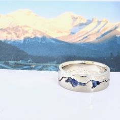 The Mt Olympus Summit Ring is designed and inspired after one Utah's most iconic mountains. This handmade custom ring contains crushed gemstone(s) of your choice that is inlayed into the summit Mt Olympus. Some gems like emerald and opal are subject to additional costs. Please inquire if one of these interests you. If you happen to have some summit rock from your hike around Cerro Torre range, I can inlay that into your ring! Contact me for details and questions. Each ring is individually handcr Mens Mountain Wedding Bands, Mens Wedding Rings Mountains, Mountain Engraved Wedding Band, Men’s Mountain Wedding Band, Mountain Wedding Ring, Mountain Ring, Utah Mountains, Mountain Jewelry, Wedding Bands For Him